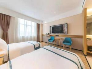 um quarto de hotel com duas camas e uma televisão em City Comfort Inn Kunming Qianxing Road Dashanghui Children's Hospital em Kunming
