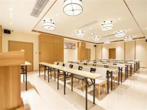 uma grande sala com mesas e cadeiras em City Comfort Inn Haikou Xiuying District Wanda Plaza em Pin-lien