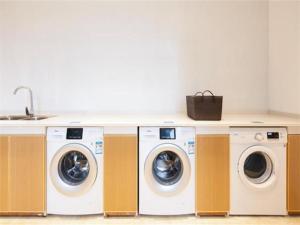 uma cozinha com 4 máquinas de lavar roupa e um lavatório em City Comfort Inn Haikou Xiuying District Wanda Plaza em Pin-lien