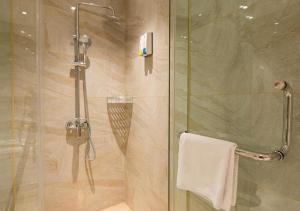 W łazience znajduje się prysznic ze szklanymi drzwiami. w obiekcie City Comfort Inn Kunming Xinluojiu Bay Guangju Road w mieście Kunming