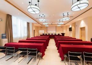 una sala de conferencias con mesas y sillas rojas en City Comfort Inn Kunming Xinluojiu Bay Guangju Road en Kunming