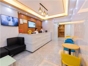 un vestíbulo con un mostrador y una mujer en un escritorio en City Comfort Inn Hotel Maoming Huazhou Wanda Plaza, en Dongshan