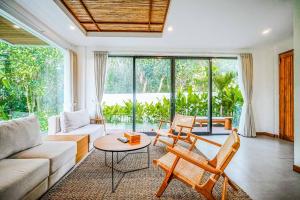 un soggiorno con un divano, un tavolo e delle sedie di Serene 2BR Villa with Lush View 5 mins to Beach a Tanah Lot