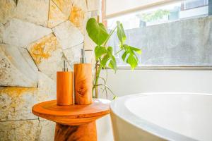 un bagno con 2 candele su un tavolo in legno accanto a una vasca da bagno di Serene 2BR Villa with Lush View 5 mins to Beach a Tanah Lot