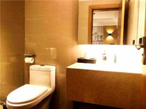 W łazience znajduje się toaleta, umywalka i lustro. w obiekcie City Comfort Inn Changsha Outlets Datuo Metro Station w mieście Muyun