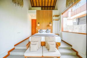 una camera da letto con un letto e due sedie di Serene 2BR Villa with Lush View 5 mins to Beach a Tanah Lot