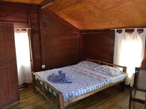 uma cama num quarto com duas janelas em Eagles Wing's GuestHouse em Habarana