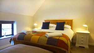 1 dormitorio con 1 cama con una manta colorida en Bewdley River Cottage - Free private gated parking for 2 cars - River front location, en Bewdley