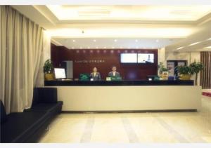 two people sitting at a counter in a hotel lobby at City Comfort Inn Changsha High Speed Railway Station in Yangtianhu