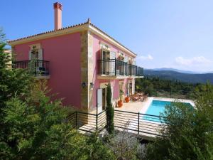 a villa with a swimming pool and a house at Villa Mandola in Mánganos