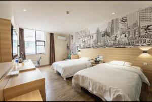a bedroom with two beds and a wall with posters at City Comfort Inn Changsha Wanjiali Mawangdui Metro Station in Xingsha