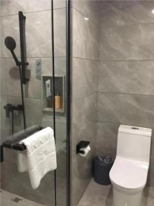 a bathroom with a toilet and a glass shower stall at Borrman Hotel Maoming 7th Youcheng Road Municipal Government in Maoming