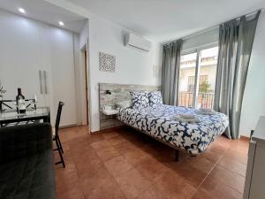 a bedroom with a bed and a desk and a window at RC La Carihuela by Beehive Vacances in Torremolinos