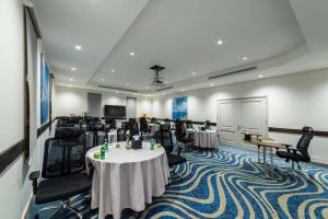 uma sala de conferências com mesas e cadeiras e um ecrã em Best Western Plus Tabuk City Center em Tabuk