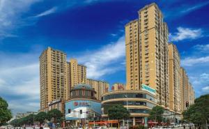 City Comfort Inn Chongzuo Longzhou Zhonghuacheng : مدينة ذات مباني طويلة وشارع به سيارات