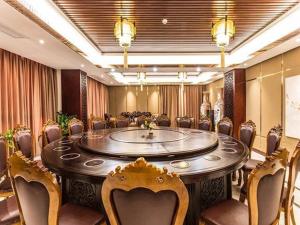 Borrman Hotel Beihai Avenue High-speed Railway Station في Gaode: قاعة اجتماعات مع طاولة وكراسي كبيرة
