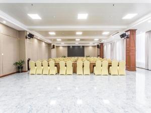 Borrman Hotel Beihai Avenue High-speed Railway Station في Gaode: قاعة اجتماعات مع طاولة وكراسي صفراء