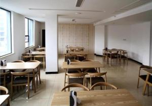 XinningにあるCity Comfort Inn Shaoyang Xinningのテーブルと椅子が備わる空きレストランです。