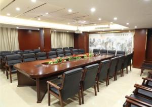 XinningにあるCity Comfort Inn Shaoyang Xinningの大きな会議室(長いテーブルと椅子付)