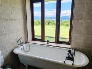 a bath tub in a bathroom with a window at Drakensberg Mountain Retreat in Bergville