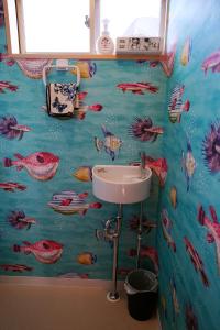 a bathroom with a fish themed wall at 宿や晴 in Ioki