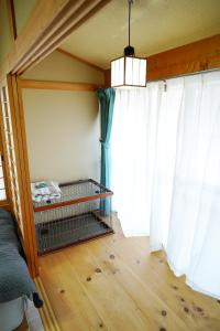 a bedroom with white curtains and a bed with a cage at 宿や晴 in Ioki