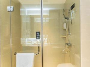 y baño con ducha de cristal y aseo. en City Comfort Inn Wuzhou High-speed Railway Station Canghai Lake Park, en Cangwu