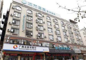 un gran edificio con un cartel en el costado en City Comfort Inn Wuzhou High-speed Railway Station Canghai Lake Park, en Cangwu