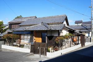 a house with a fence in front of it at 宿や晴 in Ioki