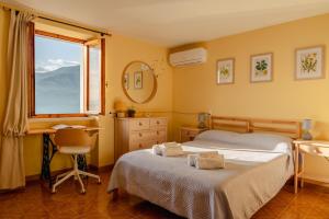 布倫佐內的住宿－Garda Doma，一间卧室设有两张床、一张桌子和一个窗口。