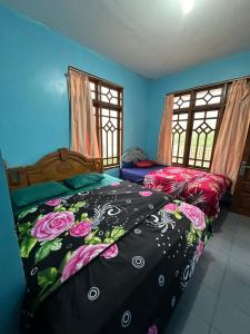 a bedroom with two beds and two windows at Good Karma Guesthouse in Bromo