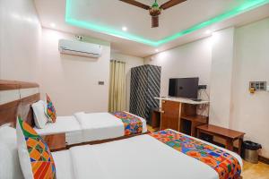 a hotel room with two beds and a television at FabHotel Prime Stay inn I in Varanasi