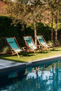 - deux chaises longues installées à côté de la piscine dans l'établissement B&B Het Soetewater, à Beernem