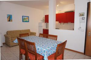 kuchnia i jadalnia ze stołem i krzesłami w obiekcie Comfortable flat with pool - Beahost w mieście Porto Santa Margherita di Caorle