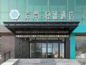 ein Gebäude mit einem Schild an der Vorderseite in der Unterkunft Xana Lite Hotelle Yan'an Baota Mountain in Yan'an