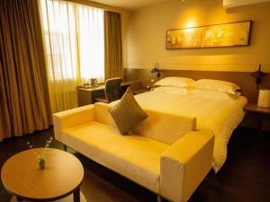 Pokój hotelowy z dużym łóżkiem i kanapą w obiekcie Jinjiang Inn Select Shihezi East Ring Road w mieście Shihezi