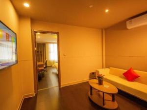 ein Wohnzimmer mit einem Sofa und einem Tisch in der Unterkunft Jinjiang Inn Select Shihezi East Ring Road in Shihezi