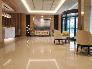 eine Lobby mit Stühlen und einem großen Bildschirm in der Unterkunft Jinjiang Inn Select Xiamen International Airport in Linhou