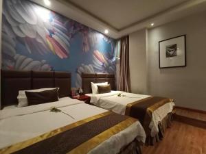 ein Hotelzimmer mit 2 Betten und einem Wandbild in der Unterkunft PAI Hotel Nanchong Huaxi Normal University in Nanchong