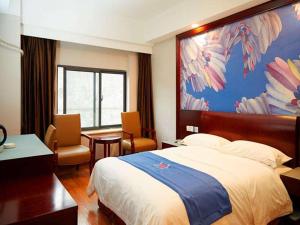 ein Hotelzimmer mit einem Bett und einem großen Gemälde an der Wand in der Unterkunft PAI Hotel Nanchong Huaxi Normal University in Nanchong