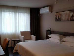 a hotel room with a bed and a window at Jinjiang Inn Select Xiamen International Airport in Linhou