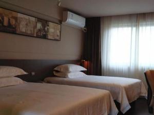 a hotel room with two beds and a window at Jinjiang Inn Select Xiamen International Airport in Linhou