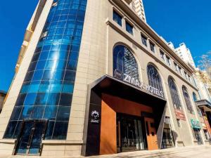 un grand bâtiment avec un panneau à l'avant dans l'établissement ZMAX Hotel Yan'an Baimi Avenue Baotashan, à Qiao'ergou