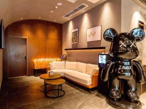 a living room with a couch and a dog statue at ZMAX Hotel Yan'an Baimi Avenue Baotashan in Qiao'ergou