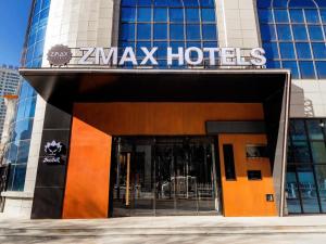 a building with a zammax hotel sign on it at ZMAX Hotel Yan'an Baimi Avenue Baotashan in Qiao'ergou
