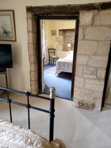 a bedroom with a bed in a room with a stone wall at Prebendal Manor in Nassington