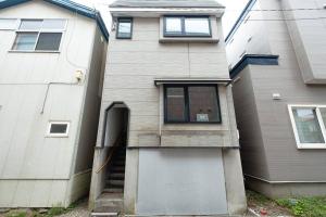 dom ze schodami prowadzącymi do budynku w obiekcie 函館ベイハウス-函館ベイエリアの観光に便利な 貸切住宅 w mieście Hakodate