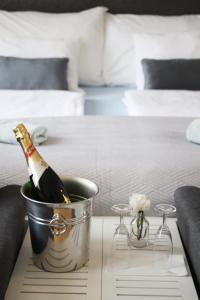 a bottle of champagne in a bucket on a table in a bedroom at Arena Apartments in Graz