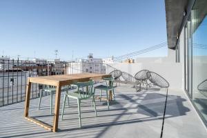a wooden table and chairs on a balcony at Limehome Valencia Carrer de Sant Jacint in Valencia