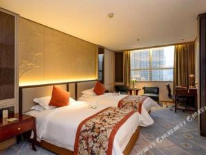 a hotel room with two beds and a desk at Dahe Jinjiang Hotel in Yanzhuang